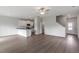 Open-concept living area with hardwood floors, a ceiling fan, and a view into the kitchen at 809 Rhino Bnd, Oxford, NC 27565