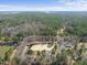 Expansive aerial shot of a horse farm surrounded by lush woodlands and a serene lake at 8809 Farrington Mill Rd, Chapel Hill, NC 27517