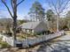 Charming home featuring a white picket fence, lush landscaping, and a serene, tree-filled setting at 8809 Farrington Mill Rd, Chapel Hill, NC 27517