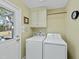 Well-lit laundry room with washer and dryer, cabinets for storage, and access to the outdoors at 8809 Farrington Mill Rd, Chapel Hill, NC 27517