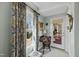 Bright sitting room with a window, curtains, a chair, a small desk, and a door to the deck at 8809 Farrington Mill Rd, Chapel Hill, NC 27517