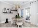 Bright dining area featuring modern chandelier, light wood floors, and a round table with seating for four at 1000 Pyrenees Way, Cary, NC 27519