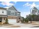 Two-story townhome boasting a brick and siding exterior with a two-car garage and well-kept landscaping at 1000 Pyrenees Way, Cary, NC 27519