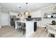 Well-lit kitchen showcasing white cabinets, stainless steel appliances, and a central island with seating at 1000 Pyrenees Way, Cary, NC 27519