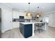 Modern kitchen featuring stainless steel appliances, white cabinets, and a contrasting blue island with barstool seating at 1000 Pyrenees Way, Cary, NC 27519