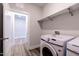 Bright laundry room with modern washer and dryer and wood-look vinyl flooring at 1009 Grey Flint Pl, Mebane, NC 27302