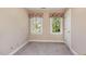 Bedroom featuring two windows providing natural light and neutral colored walls and carpet at 101 Rustic Wood Ln, Cary, NC 27518