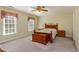 Spacious bedroom with large windows, a ceiling fan, and carpeted floor, bathed in natural light at 101 Rustic Wood Ln, Cary, NC 27518