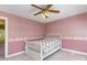 Bedroom featuring pink wallpaper and trim, a ceiling fan, and carpeted floors at 101 Rustic Wood Ln, Cary, NC 27518