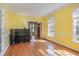 Dining room with hardwood floors, yellow walls, windows, and doors leading to other rooms at 101 Rustic Wood Ln, Cary, NC 27518