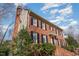 Low-angle view of a stately red brick home with black shutters and a well-manicured front yard at 101 Rustic Wood Ln, Cary, NC 27518