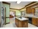Eat-in kitchen featuring an island cooktop, wooden cabinetry, and stainless steel appliances at 101 Rustic Wood Ln, Cary, NC 27518