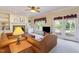 Warm living room with a brick fireplace, built-in shelves, and French doors leading to the deck at 101 Rustic Wood Ln, Cary, NC 27518