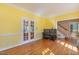 Hardwood living room featuring a piano and french doors leading to the front porch at 101 Rustic Wood Ln, Cary, NC 27518