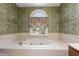 A large soaking tub beneath an arched window in the main bathroom at 101 Rustic Wood Ln, Cary, NC 27518