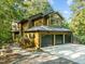 Exterior view of house featuring a three-car garage, surrounded by lush trees at 1011 Oxbow Crossing Rd, Chapel Hill, NC 27516