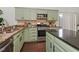 Stylish kitchen features granite countertops, stainless steel appliances, and warm, wood flooring at 104 Deep Gap Run, Cary, NC 27519