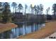 Picturesque view of the pond with its serene waters reflecting the surrounding landscape and buildings at 104 Deep Gap Run, Cary, NC 27519