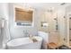 Bright bathroom features a soaking tub, walk-in shower with glass enclosure, and a window providing natural light at 107 Crescent Hill Ln, Rougemont, NC 27572