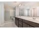 Modern bathroom featuring a double sink vanity, large mirror, and glass-enclosed shower at 1077 Kafka Dr, Fuquay Varina, NC 27526