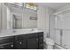 Bright bathroom features a double sink vanity with dark cabinets and a glass-enclosed shower at 1122 Briar Rose Ln, Durham, NC 27704