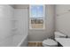 Bright bathroom featuring a shower-tub combo with modern fixtures and natural light through the window at 1122 Briar Rose Ln, Durham, NC 27704
