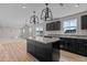 Open kitchen with gray countertops, dark cabinets, an island, and stainless appliances at 1122 Briar Rose Ln, Durham, NC 27704