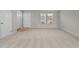 Bright living room with neutral carpet, a window, and a white door at 1122 Briar Rose Ln, Durham, NC 27704