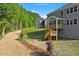 A lush backyard featuring a spacious lawn, complemented by a wooden deck and stairwell for outdoor enjoyment at 124 Hemlock Falls Trl # 189, Raleigh, NC 27603