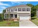 Charming two-story home with a manicured lawn, attached garage, and a mix of brick and gray siding at 124 Hemlock Falls Trl # 189, Raleigh, NC 27603