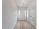Bright foyer with wood flooring, a white front door, elegant lighting, and glass french doors to the side at 124 Hemlock Falls Trl # 189, Raleigh, NC 27603