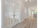 Close up of foyer with glass french doors, white trim, and hardwood floors, leading into the home's interior at 124 Hemlock Falls Trl # 189, Raleigh, NC 27603