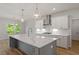 Bright kitchen boasts a large island, white cabinets, stainless steel appliances and modern pendant lighting at 124 Hemlock Falls Trl # 189, Raleigh, NC 27603