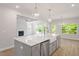 Bright kitchen featuring a large island with a farmhouse sink, views of the fireplace, and backyard access at 124 Hemlock Falls Trl # 189, Raleigh, NC 27603