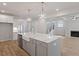 Open-concept kitchen with a large island, stainless steel appliances, and a view of the adjacent living area at 124 Hemlock Falls Trl # 189, Raleigh, NC 27603