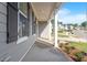 Side porch featuring a concrete floor and white columns, offering views of the street and surrounding neighborhood at 124 Hemlock Falls Trl # 189, Raleigh, NC 27603