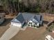 Aerial view of home with manicured front yard, long driveway, and two car garage at 127 Landfall Ln, Smithfield, NC 27577