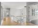 Hallway with glass railings, light wood floors, and a glass display table at 132 Edward Booth Ln, Durham, NC 27713
