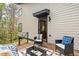 Relaxing back porch featuring modern furniture, a stylish rug, and a view of the surrounding greenery at 1407 Carroll St, Durham, NC 27707