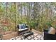 Outdoor deck area featuring stylish seating, a glass table, and serene views of surrounding trees and nature at 1407 Carroll St, Durham, NC 27707