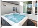 Outdoor hot tub surrounded by sleek gray siding and framed by large windows for privacy and natural light at 153 Abercorn Cir, Chapel Hill, NC 27516