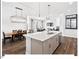 Bright, open kitchen featuring a large island with white countertops and stainless steel appliances, seamlessly connected to the living areas at 153 Abercorn Cir, Chapel Hill, NC 27516