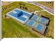 Aerial view of basketball and pickleball courts within a fenced area and surrounded by green space in a well-maintained community at 153 Abercorn Cir, Chapel Hill, NC 27516