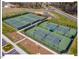Aerial view of the community tennis courts featuring well-maintained green surfaces and lighting for evening games at 153 Abercorn Cir, Chapel Hill, NC 27516