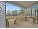 View from covered back porch with wood flooring and railing overlooking spacious backyard and greenway at 20 Hickory Hollow Cir, Youngsville, NC 27596