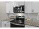 Close up of sleek stainless steel appliances, granite counters, and white subway tile backsplash at 20 Hickory Hollow Cir, Youngsville, NC 27596