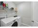 Functional laundry room with washer, dryer, shelving for storage, and light tile floors at 20 Hickory Hollow Cir, Youngsville, NC 27596