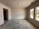 Unfinished living room area featuring sheetrocked walls, two windows for natural light, and a doorway at 20 Trescott St, Smithfield, NC 27577