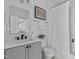 Well-lit bathroom featuring a vanity, toilet, and shower with white tiling and modern fixtures at 2002 Moody Ln, Durham, NC 27701