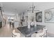 Open dining area with a dark wood table, upholstered chairs, and modern lighting adjacent to the kitchen at 2002 Moody Ln, Durham, NC 27701